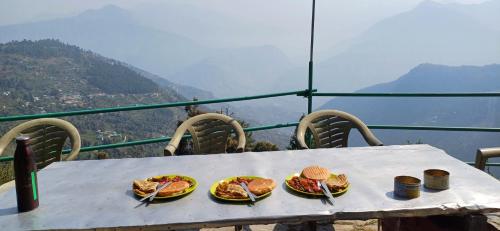 a table with plates of food on top of a mountain at The Shire Snower in Kulu