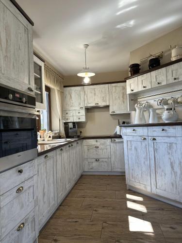 a large white kitchen with white cabinets and appliances at Ostoja Jeziorak Jezierzyce in Makowo