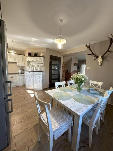 a kitchen and dining room with a table and chairs at Ostoja Jeziorak Jezierzyce in Makowo