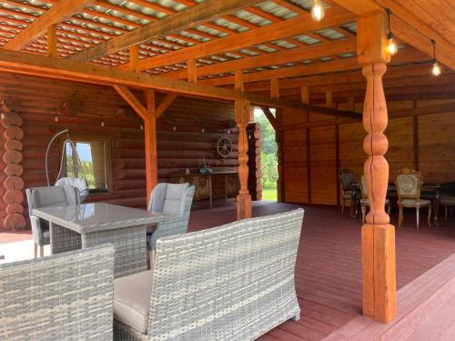 a porch of a log cabin with a table and chairs at Jaunkades in Dzeņi