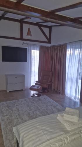 a bedroom with a bed and a chair and a tv at Casa Damian DROBETA in Drobeta-Turnu Severin