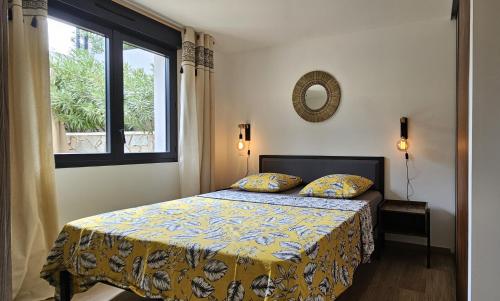 - une chambre avec un lit doté d'un couvre-lit jaune et d'une fenêtre dans l'établissement Appartement bas de villa avec accès piscine, à Ventiseri