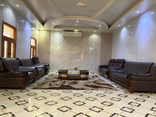 a lobby with leather furniture and a marble wall at AlZaeem Resort & Hotels in Barka