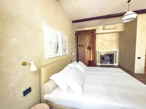 a bedroom with a bed with white pillows and a fireplace at Pantheon Urbes Collection in Rome