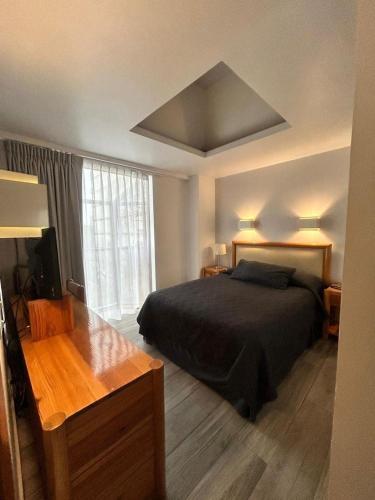 a bedroom with a bed and a table and a window at Suites Arquimedes 33 in Mexico City