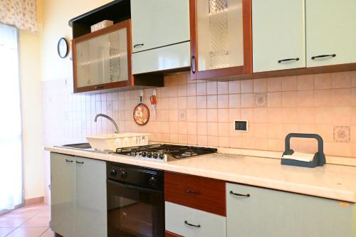 a kitchen with white cabinets and a stove top oven at SE152 - Senigallia, delizioso trilocale fronte mare in Senigallia