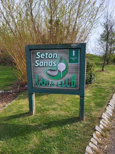 a sign for a golf club in the grass at 61 St Andrew's 3 bedroom Cozy Caravan near Edinburgh Seton Sands Holiday Village in Port Seton