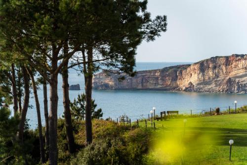 a golf course with a view of a body of water at Nativo Sea Garden in Nazaré