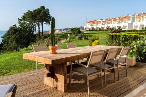 a wooden table and chairs on a deck at Nativo Sea Garden in Nazaré