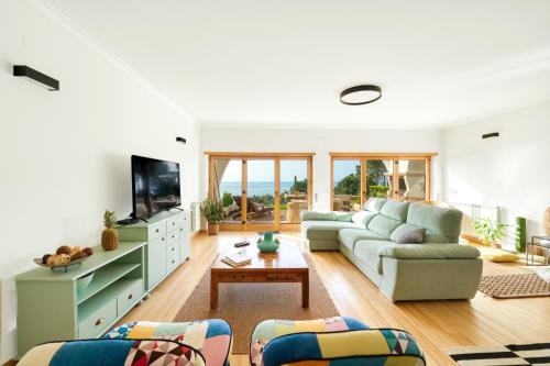 a living room with a couch and a tv at Nativo Sea Garden in Nazaré
