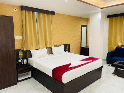 a bedroom with a bed and a blue chair at Hotel D B Palace in Patna