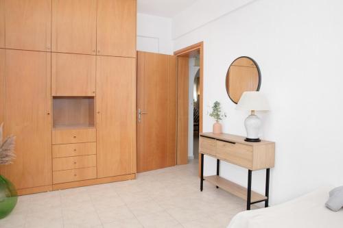 a bedroom with wooden cabinets and a table with a lamp at Petralia's Apartment in Skiathos National Airport