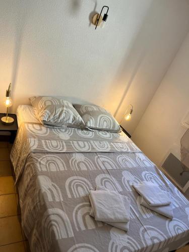 une chambre avec un lit avec deux serviettes dessus dans l'établissement Le Luxembourg, à Narbonne