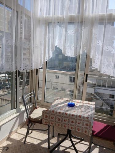un tavolo e una sedia davanti a una finestra di Denada Apartment a Durrës