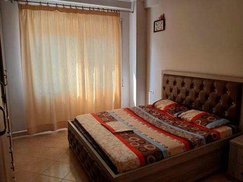 un letto in una camera da letto con una grande finestra di Denada Apartment a Durrës