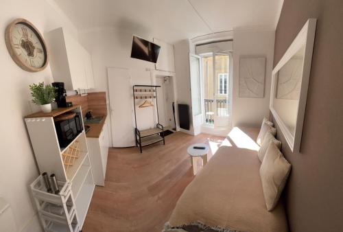 Cette chambre comprend un lit et une horloge murale. dans l'établissement Le Dauphine, à Dijon