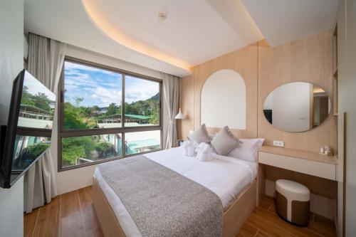 a bedroom with a large bed and a large window at now condo near beach 2bedroom in Kamala Beach