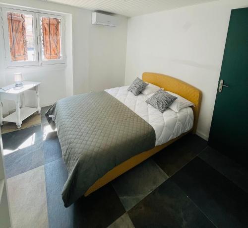 - un lit dans une chambre avec une table et une fenêtre dans l'établissement Maison de ville château Gombert, à Marseille