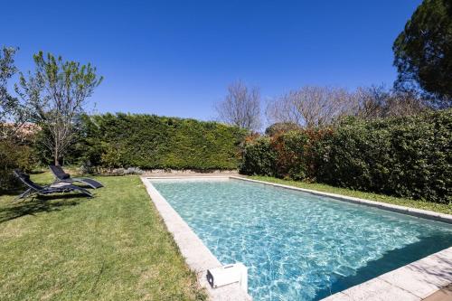 - une piscine avec une chaise dans la cour dans l'établissement Le Mazet du Sablas, à Montaren-et-Saint-Médiers