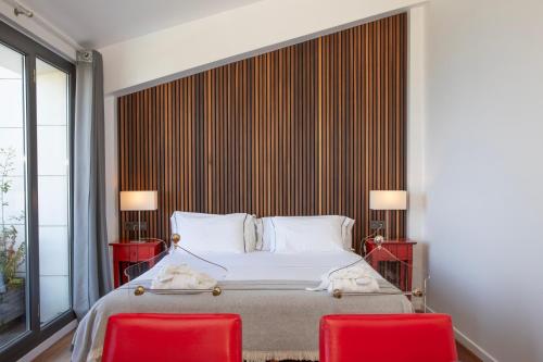 a bedroom with a bed and two red chairs at Hotel Arbe in Mutriku