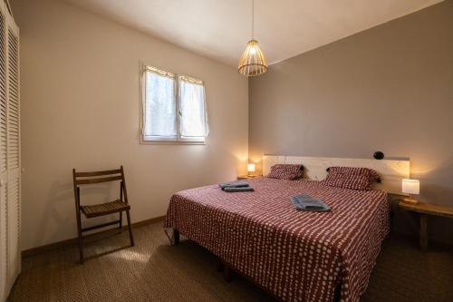 une chambre avec un lit, une chaise et une fenêtre dans l'établissement Le Mazet du Sablas, à Montaren-et-Saint-Médiers