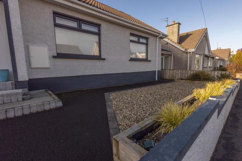 ein Haus mit einem Garten davor in der Unterkunft The Seahorse Portrush in Portrush