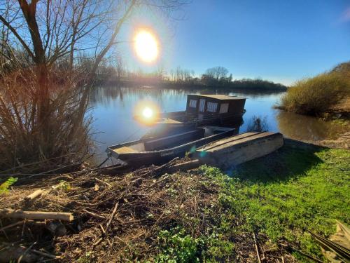 un petit bateau assis sur le bord d'une rivière dans l'établissement Gîte au coeur de la Touraine, à La Chapelle-sur-Loire