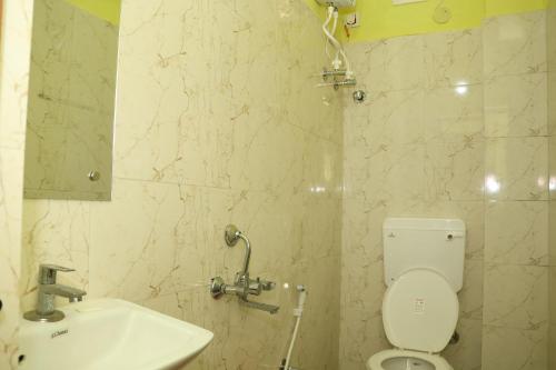 a bathroom with a white toilet and a sink at Park kasba Inn in Kolkata