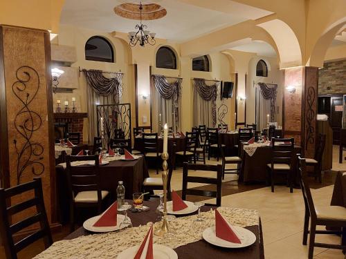 a restaurant with tables and chairs in a room at Pensiunea CASA MOLDOVEANA in Piatra Neamţ