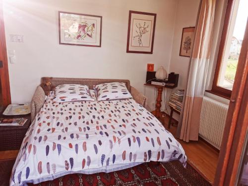 a bedroom with a bed with two pillows on it at Maison LES 3 ROSES in Wolfisheim