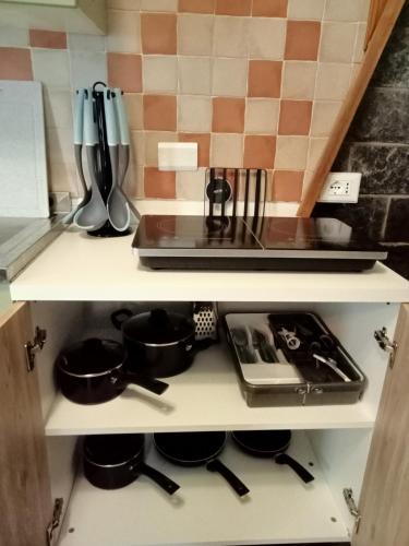 a kitchen shelf with pots and pans on it at Tana Morenica in Bollengo