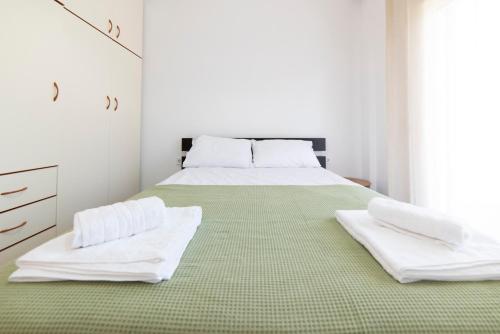 a white bedroom with a bed with white towels on it at Annas Apartment Kalithea in Kallithea Halkidikis