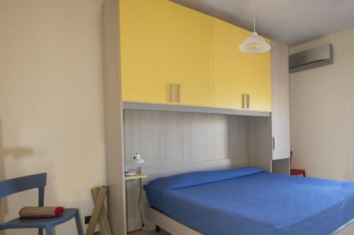 a bedroom with a blue bed and yellow cabinets at Villa Vella in Sciacca