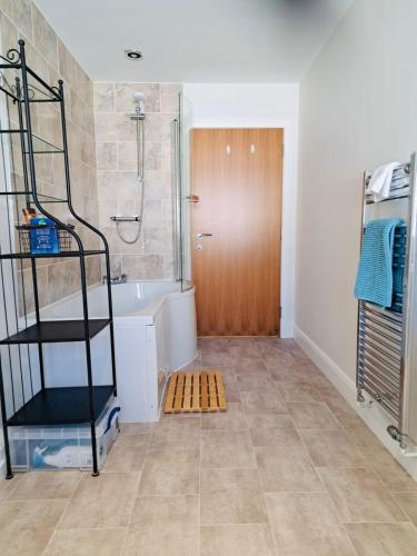 a bathroom with a shower and a bath tub at Clyde Cottage in Lamington
