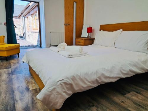 a large white bed in a room with a window at Clyde Cottage in Lamington