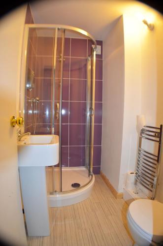 a bathroom with a shower and a sink and a toilet at Birchfields Guest House in Manchester