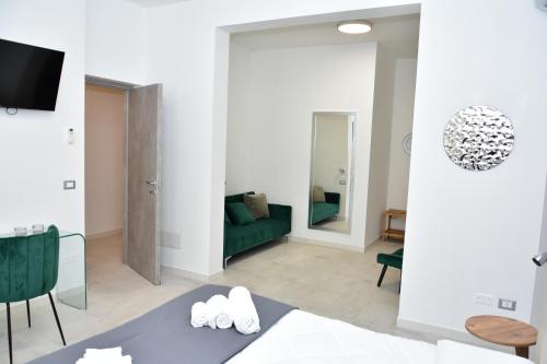 a living room with a green couch and a mirror at Yllen Rooms in Avola