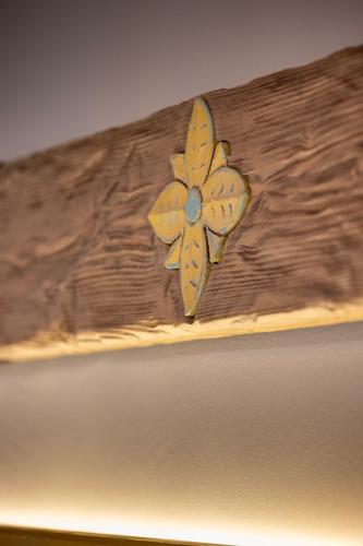 a wooden headboard with a yellow flower on it at Matzato in Monodendri