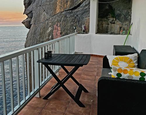 a table and a chair on a balcony with the ocean at Sea lover's nest in Los Realejos