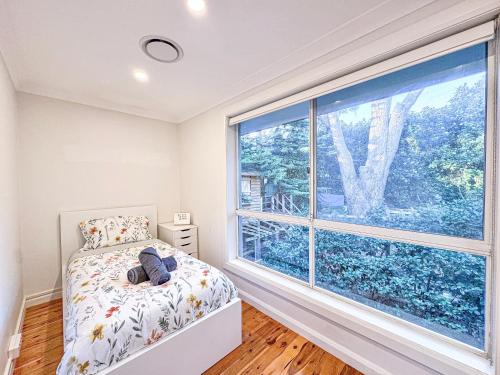 Ένα ή περισσότερα κρεβάτια σε δωμάτιο στο Spacious 4-bedrooms apartment in West Ryde with WiFi, AC