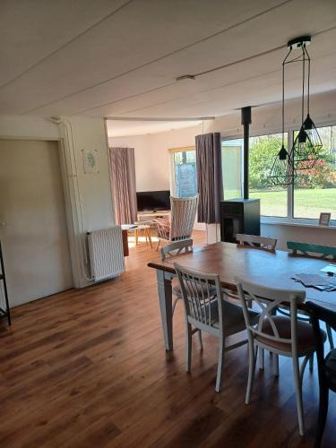 a living room with a dining room table and chairs at Bungalow net buiten Zuidwolde in Zuidwolde