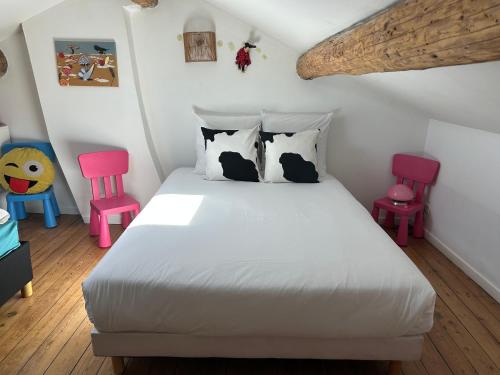 a bedroom with a bed and two pink chairs at Maison de caractère avec jardin arboré en Avignon in Avignon
