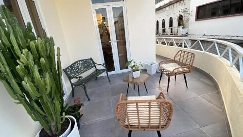 a balcony with chairs and tables and a cactus at Hotel Boutique Brisas Colonial in Santo Domingo