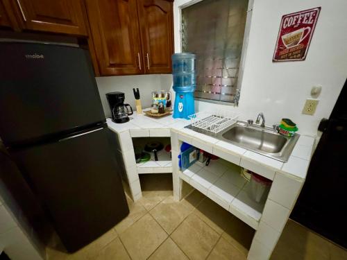a small kitchen with a sink and a refrigerator at Hostal Inn 1 in Flores