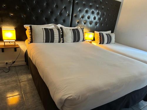 a bedroom with a large bed with two lamps on it at Hotel De La Mer in Le Barcarès