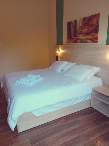 a large white bed with two folded towels on it at Hermes in Agia Marina Aegina