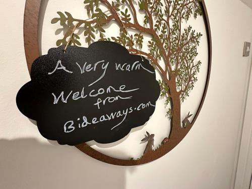 a sign that reads a very warm welcome from a tree at The Canongate Coorie in Jedburgh