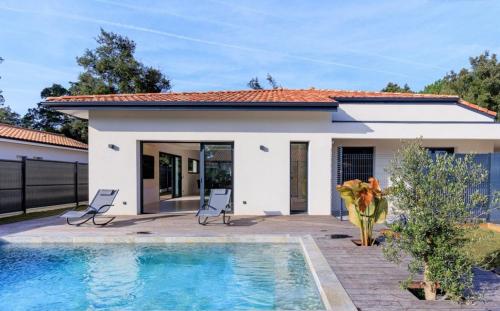 une maison avec une piscine devant dans l'établissement Luxueuse villa à deux pas des plages de Capbreton, à Labenne
