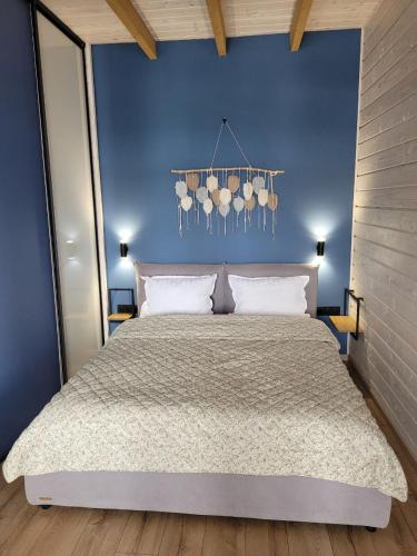 a bedroom with a large bed with a blue wall at Шале Green Land in Bukovel