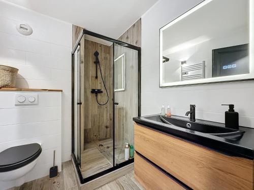 La salle de bains est pourvue d'un lavabo noir et d'une douche. dans l'établissement Peyragudes grand apparé vue montagne 2 terrasses,8 à 10 couchages , draps, serviettes de bains et menage fin séjour inclus, à Germ